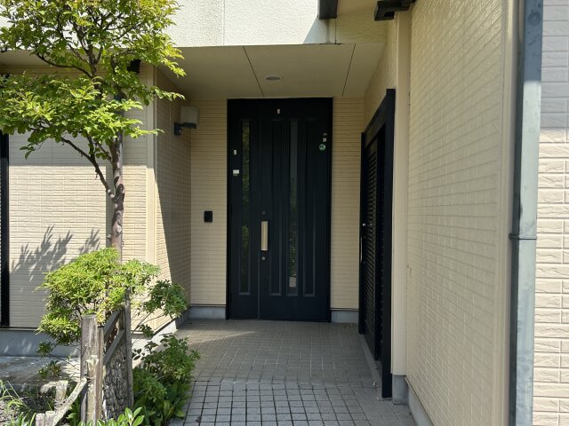 軒の深い玄関ポーチ。高さのある玄関ドアは高級感があります。写真右の引き戸も入口として利用可能です。